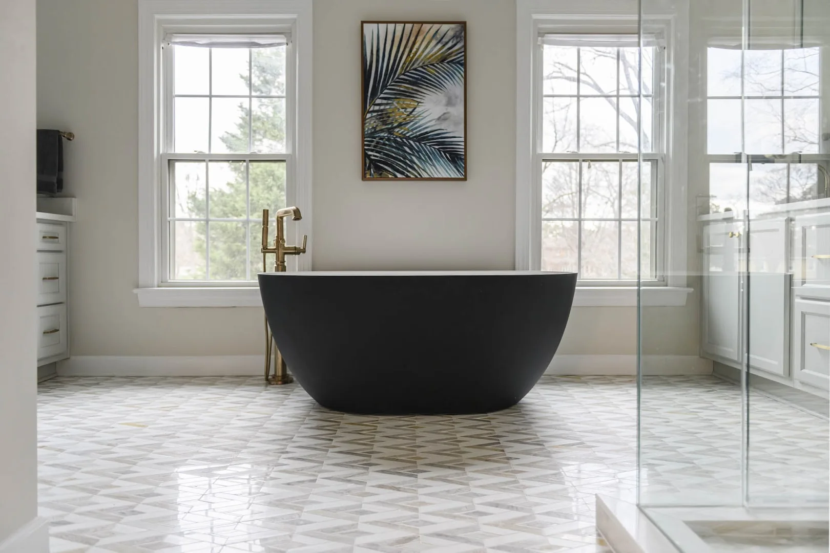 Black soaking tub in a bright finished bathroom